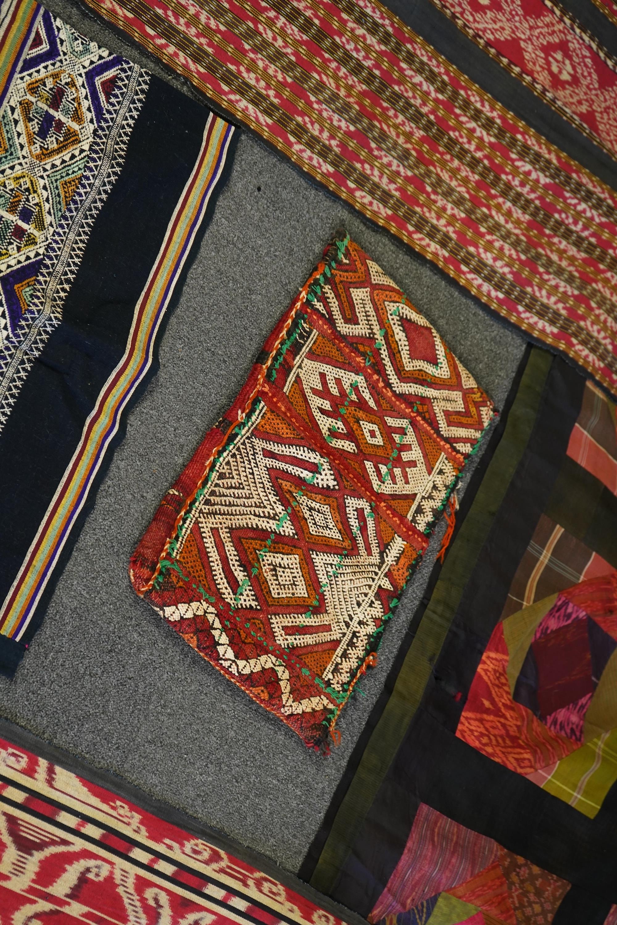 A 20th century Indonesian Sumba single Ikat shoulder cloth, a similar Celebes cloth, a Berber woven skirt and saddle bag and a patchwork cover. (5). Skirt 110cm including hessian top., Condition - some patchwork in the c